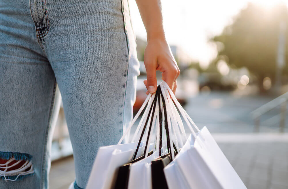 woman-hand-with-shopping-bags-and-jeans